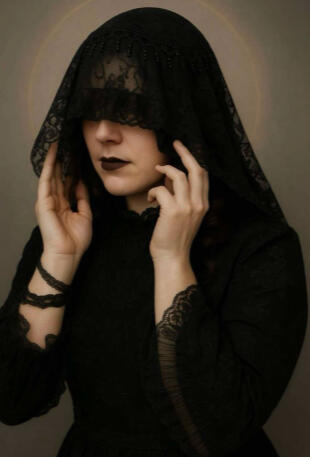 Melanie Author Photo Photo of Melanie in a dark lace veil, hands adjusting the fabric, soft lighting and a quiet, introspective pose.